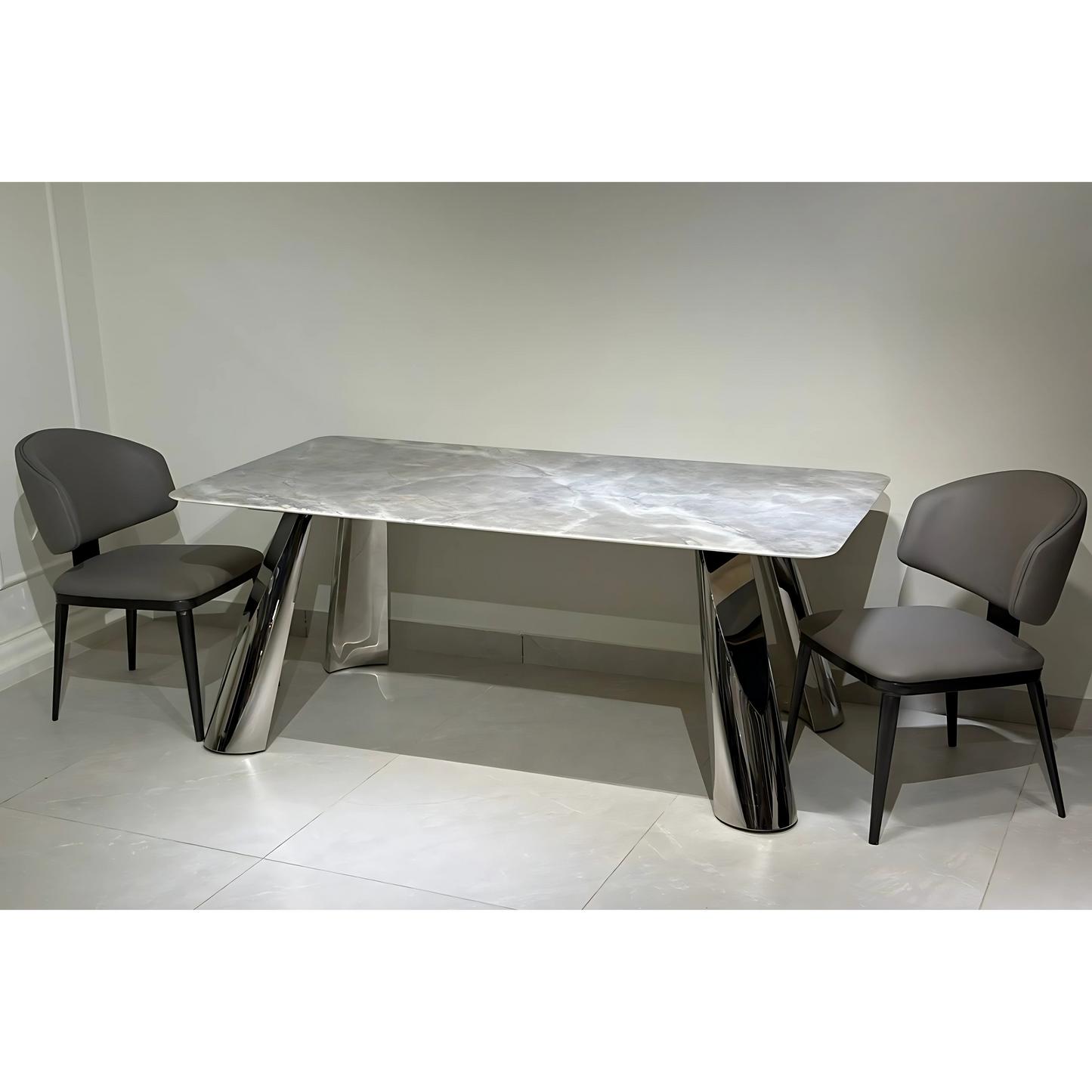 A modern rectangular dining table with a silver metallic surface and chrome legs, accompanied by two gray upholstered chairs.