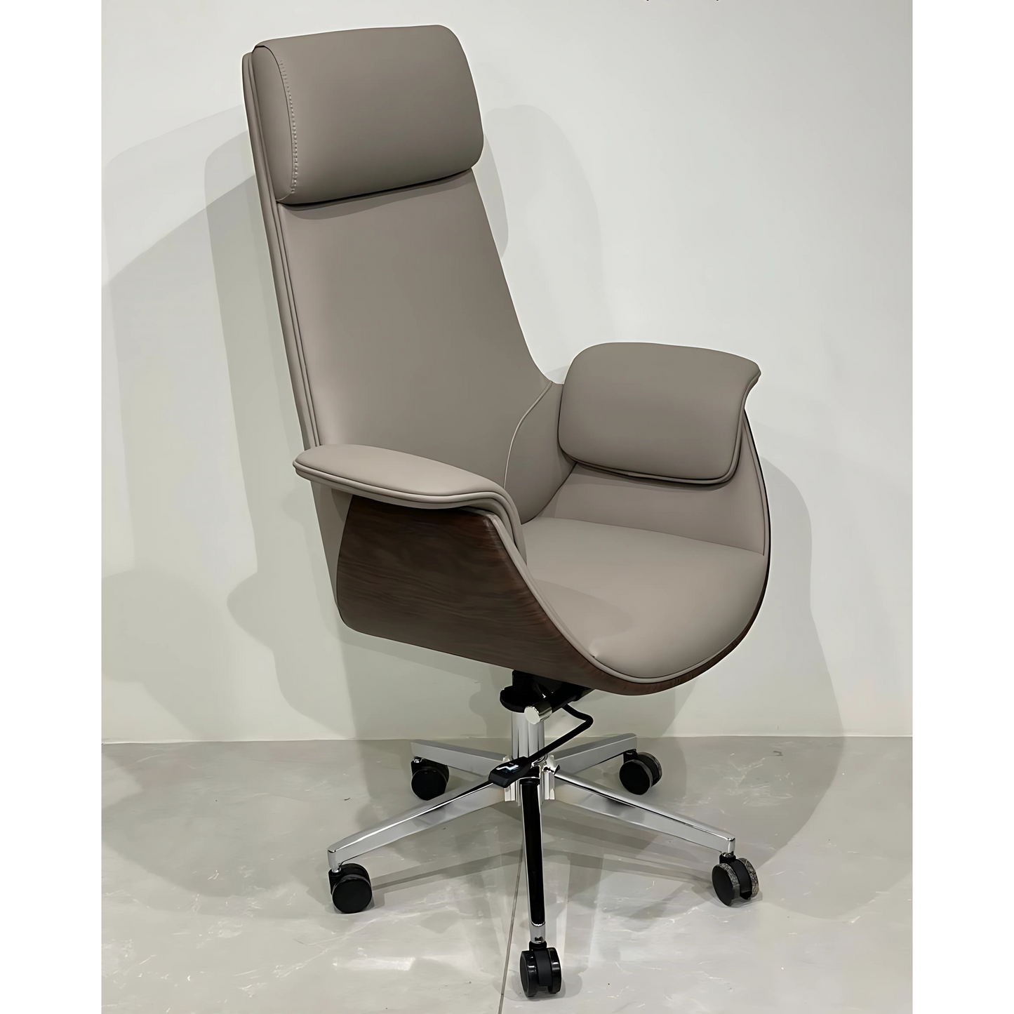 A gray office chair with a high back, headrest, and armrests on a chrome base with black caster wheels.