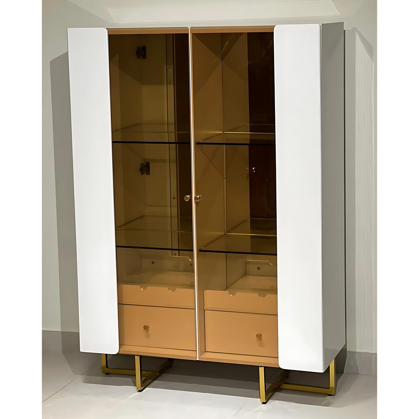 A white and beige Monarch Duo Showcase cabinet with glass doors and gold-colored metal legs.