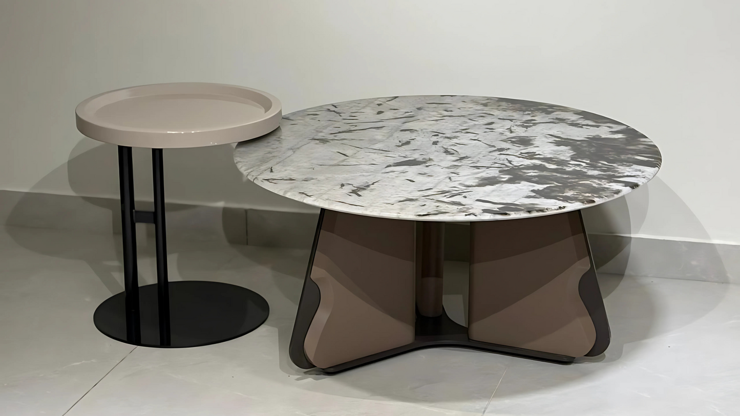 Designer marble top center table set with sand angular base and round beige accent table in a contemporary setting.