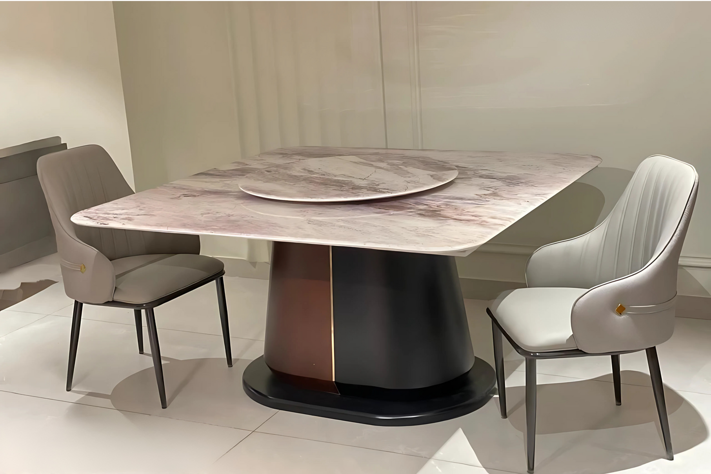 Rose marble dining table with Lazy Susan, matte black base, and two grey upholstered dining chairs in luxury modern style.