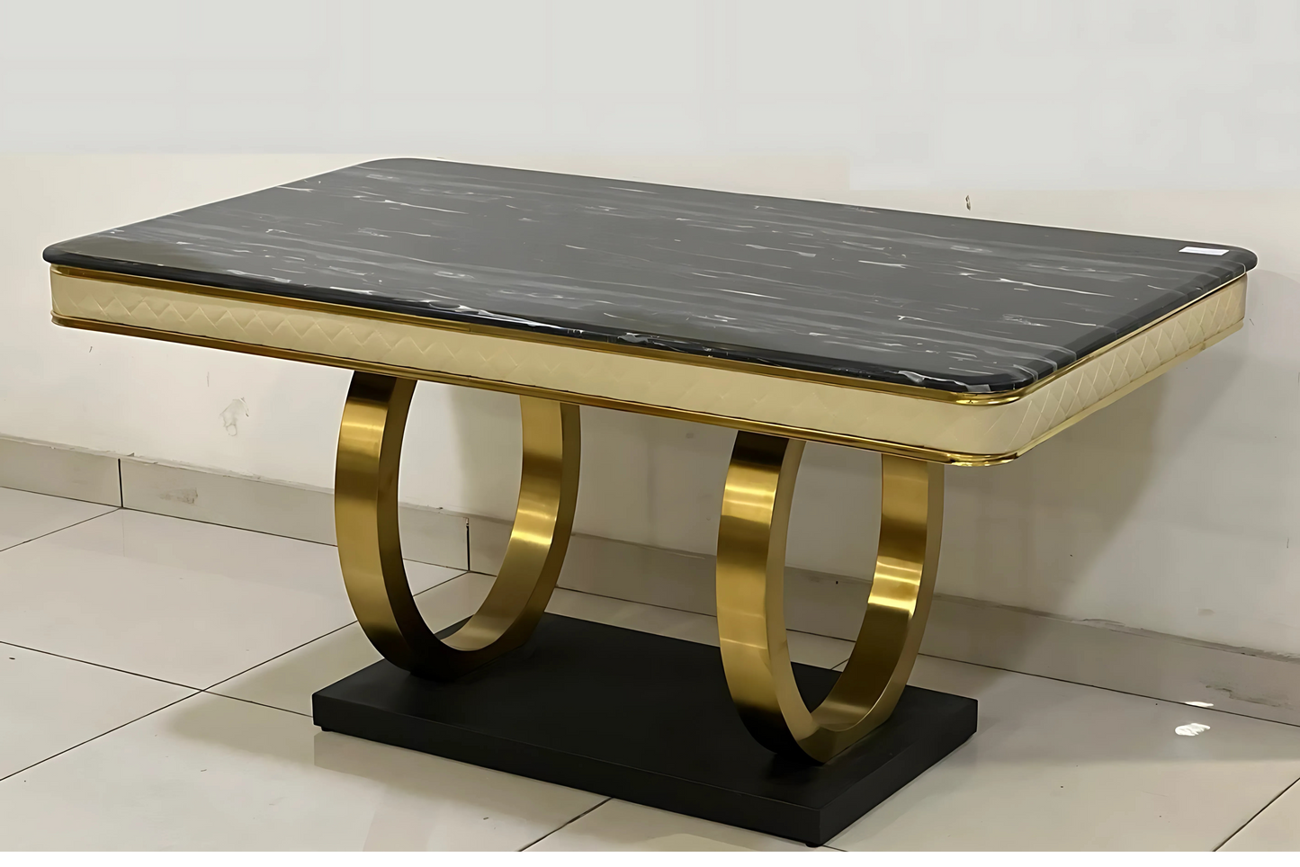 Luxury black marble dining table with gold quilted frame and looped metal base on black pedestal
