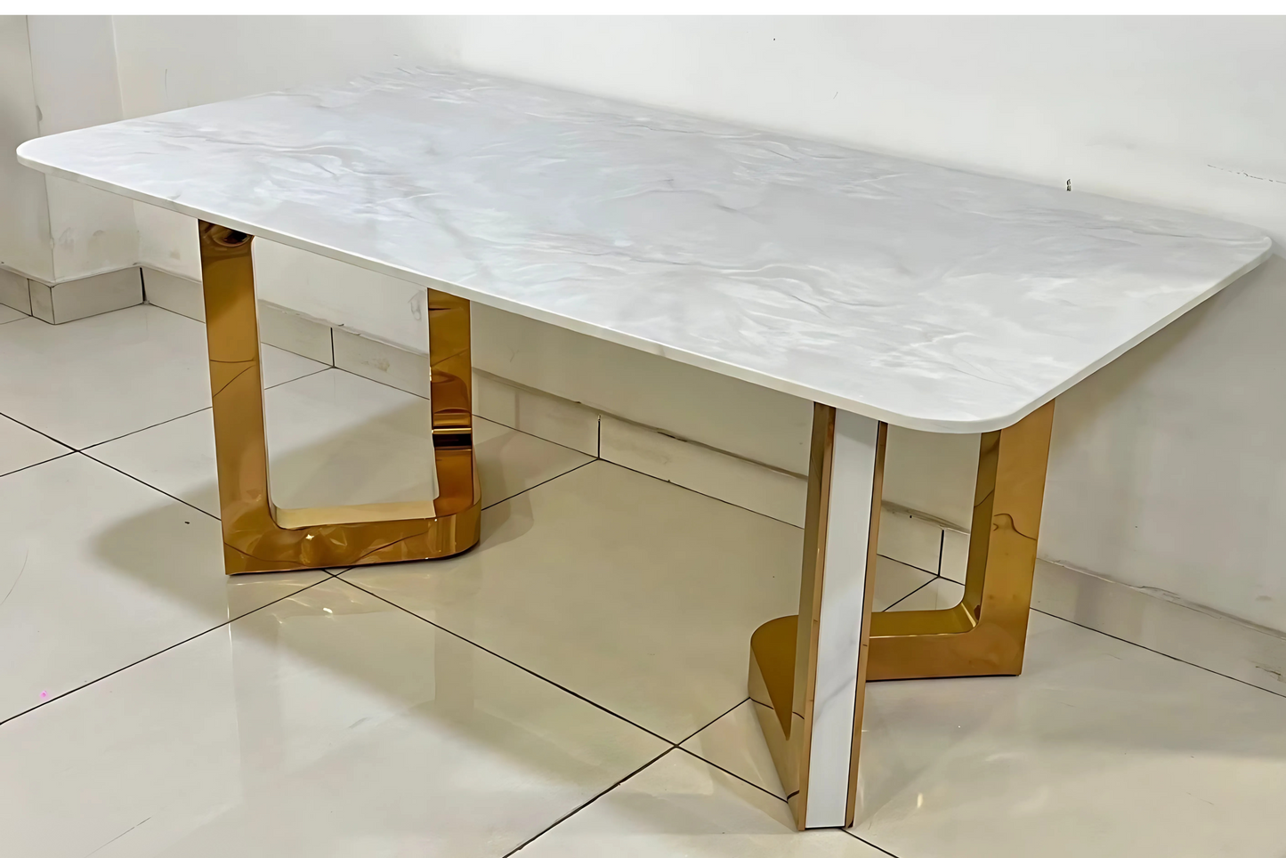 Glossy white dining table with rounded top and sculptural golden metal legs for luxury interiors