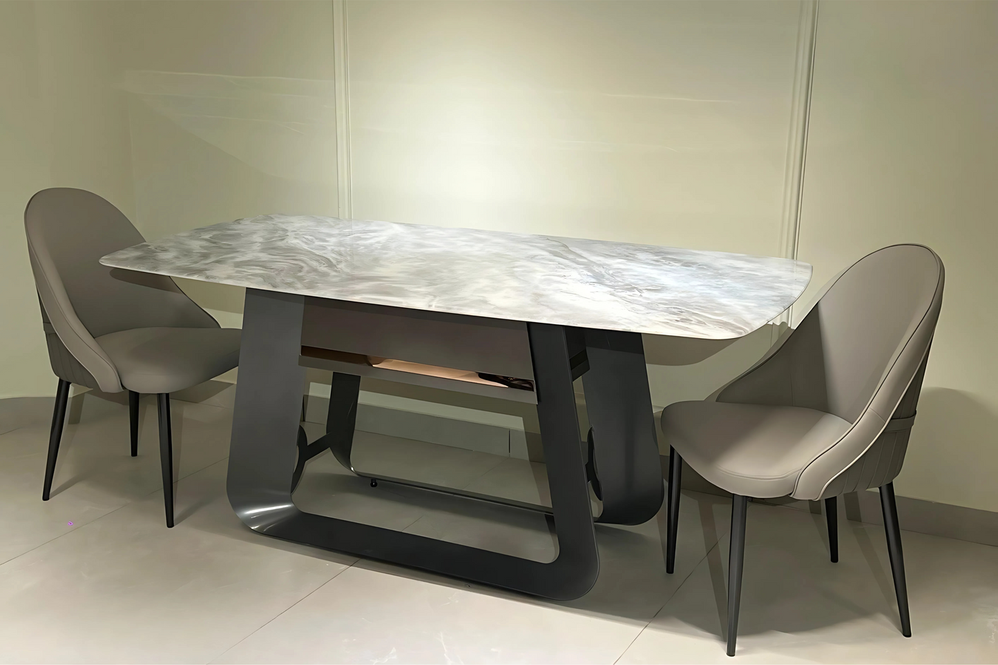 A modern dining table with a marble top and black metal legs, flanked by two grey upholstered chairs with a similar design.
