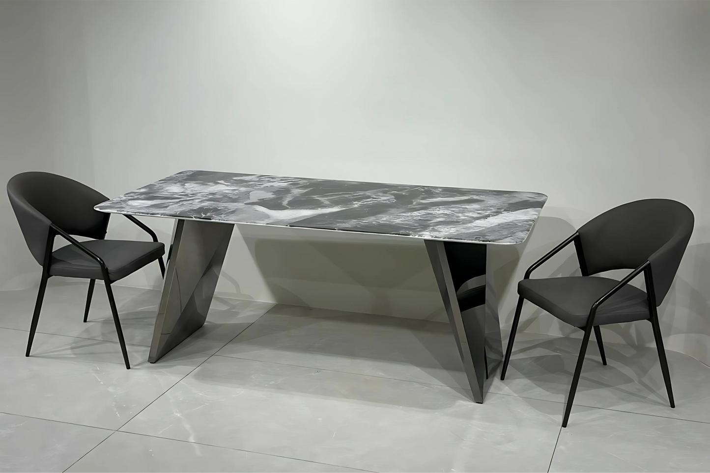 Black marble dining table with sharp V-leg metal base and modern armchairs in a luxury minimalist interior