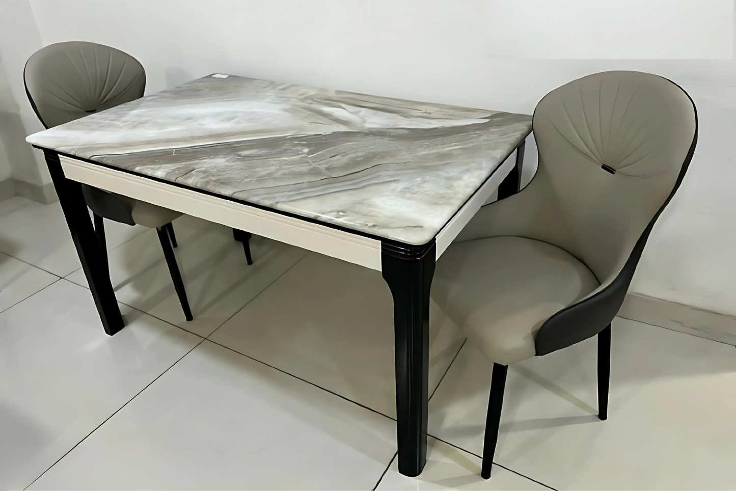 Luxury marble-look dining table with black legs and taupe pleated-back chairs in a minimalist room setting