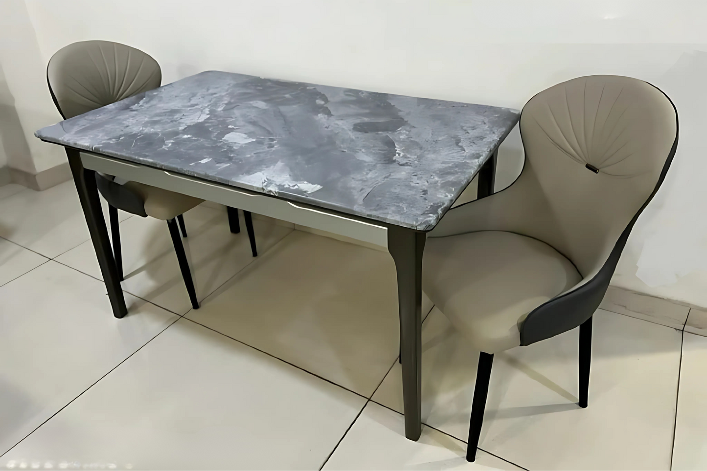 Dining table with marble surface and two chairs.