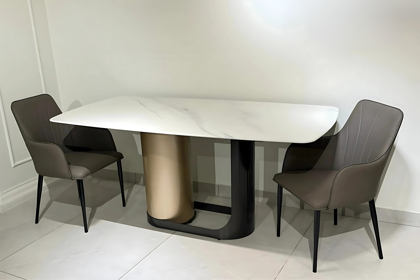 White marble dining table with champagne and black base, paired with taupe stitched chairs in modern luxury style.