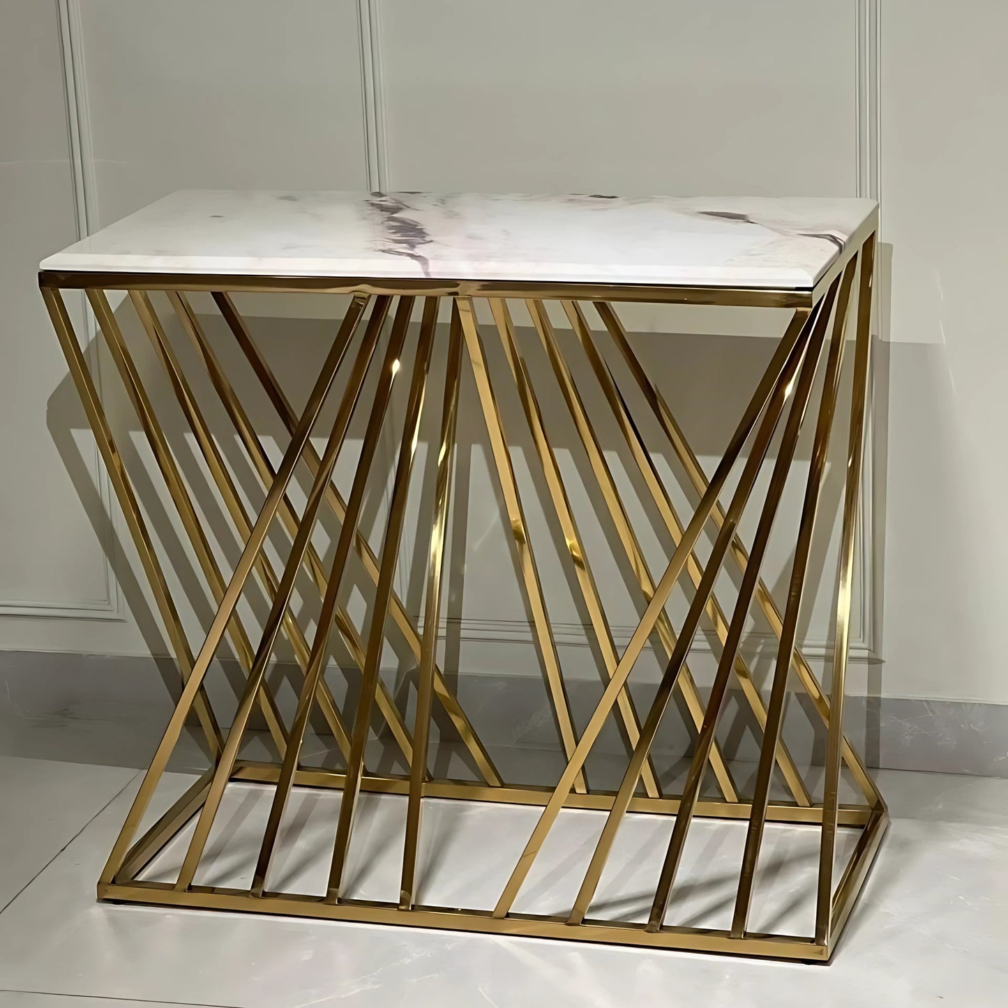 A white marble console table with gold looped legs.