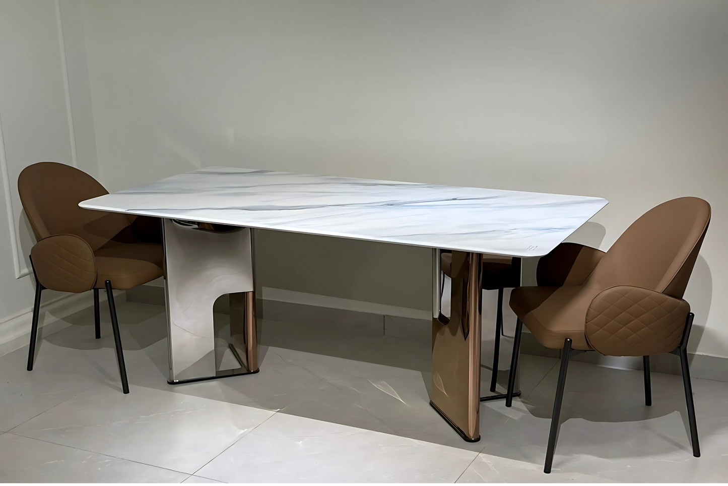 White marble dining table with rose gold arched legs and quilted taupe chairs