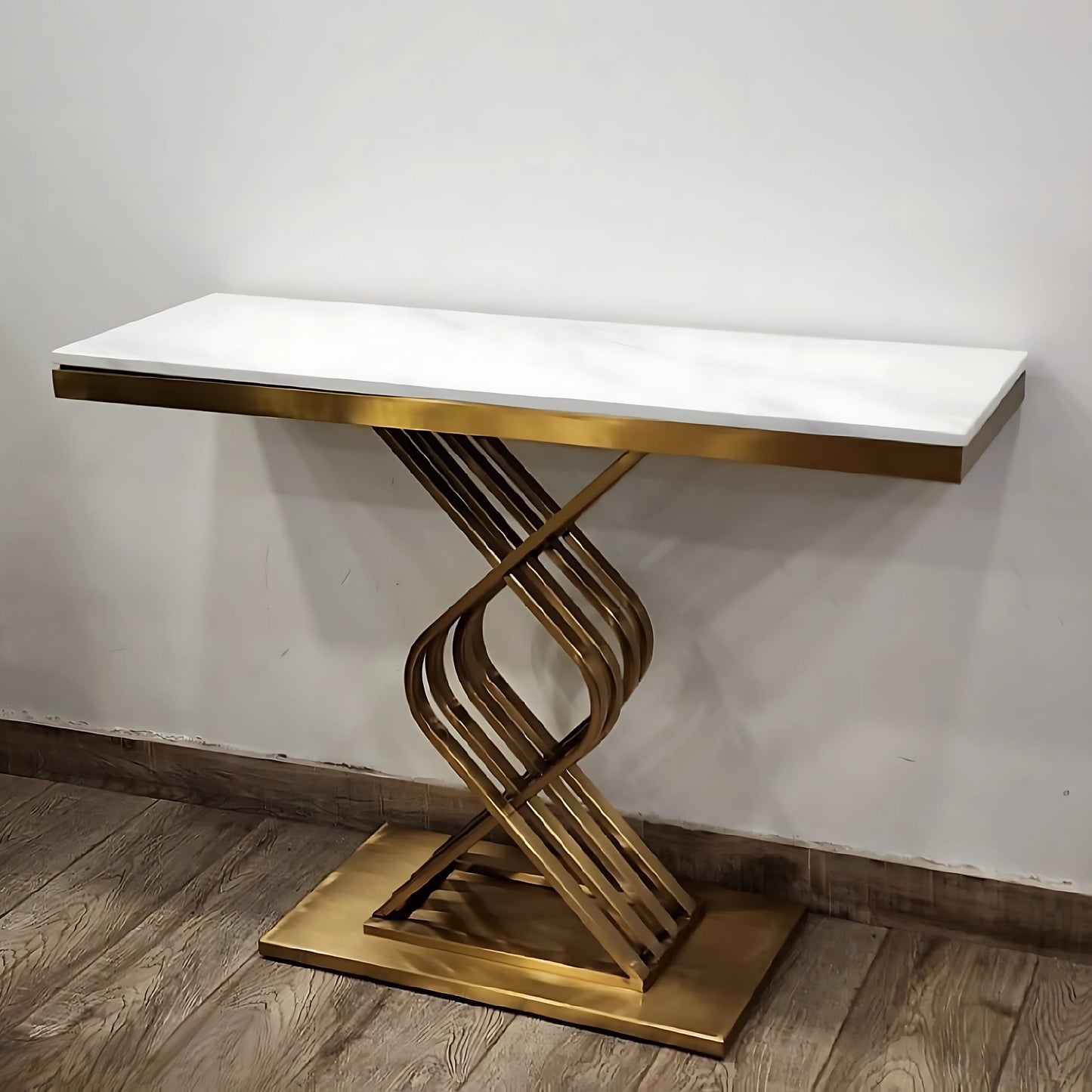 A black marble console table with gold looped legs placed against a white background.