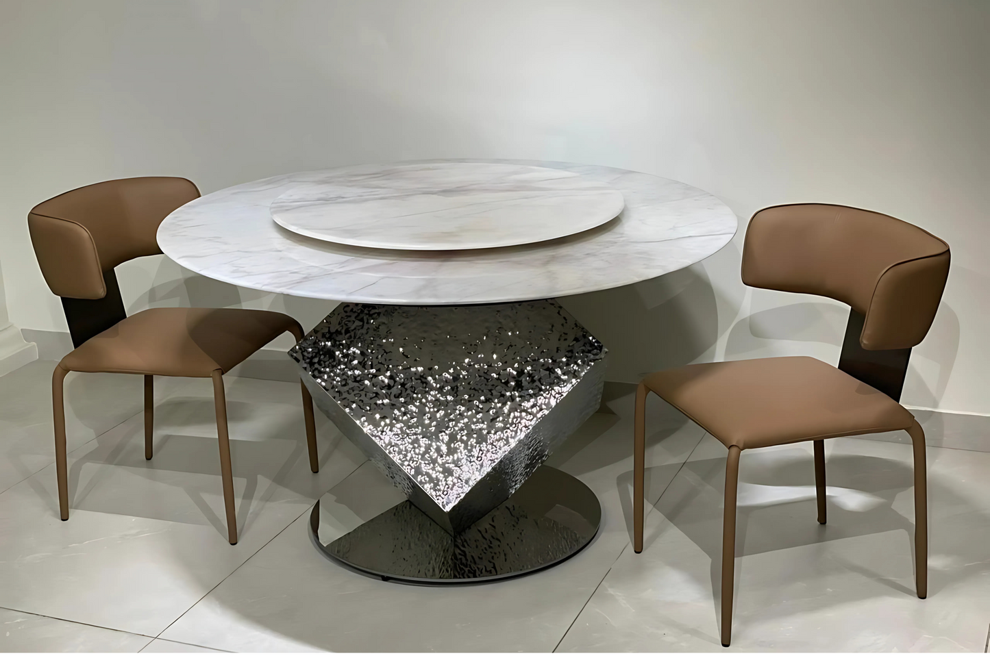 Round dining table with marble top and reflective faceted mirror base in luxury setting