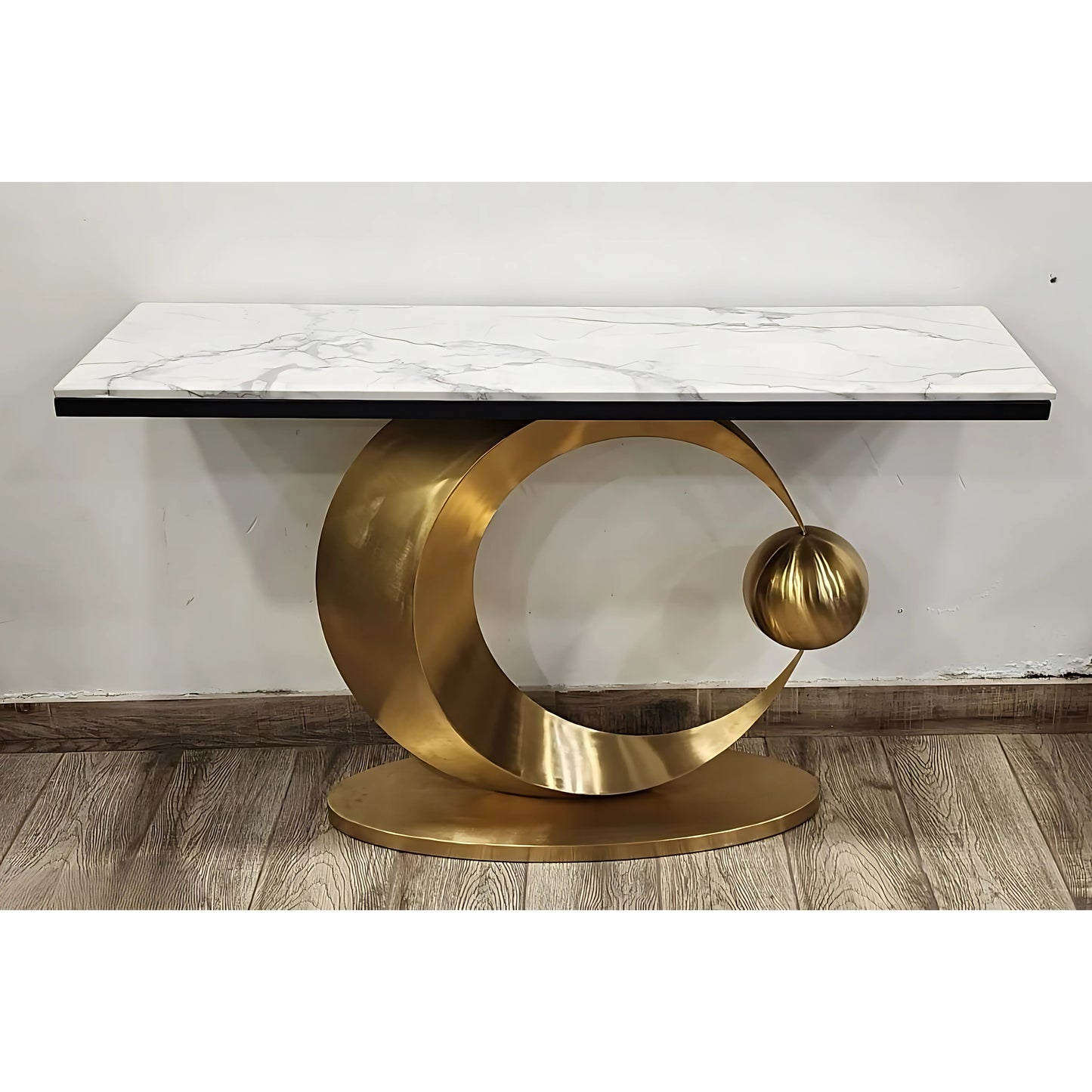 A black marble console table with gold looped legs on a white background.