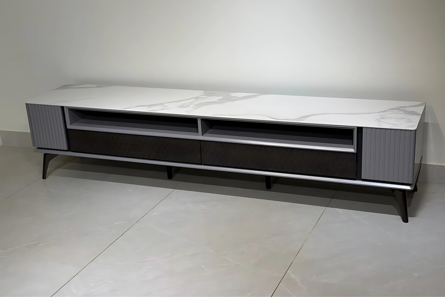 Modern TV stand with a white top and black base on a tiled floor.