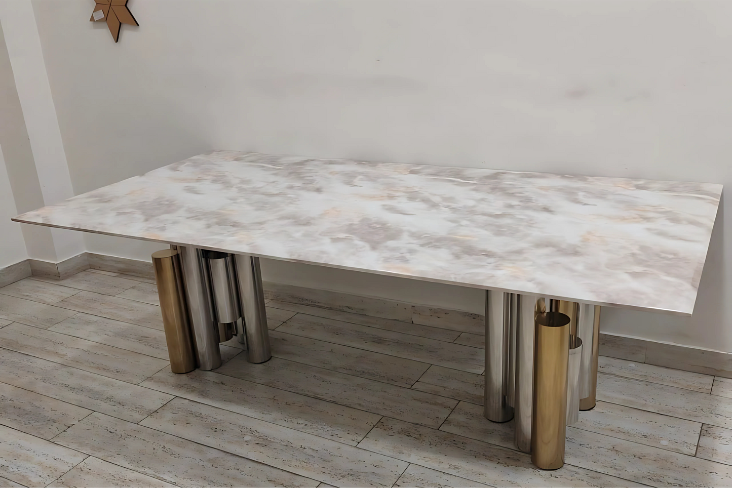 Modern luxury dining table with white marble top and mixed metallic cylindrical legs in gold and silver