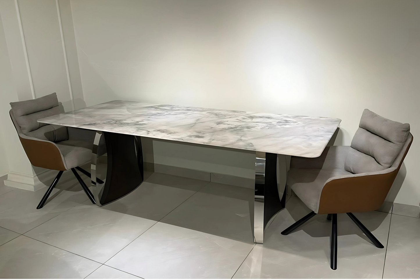 Marble dining table with chrome curved legs and grey caramel cushioned swivel chairs in luxury modern style.