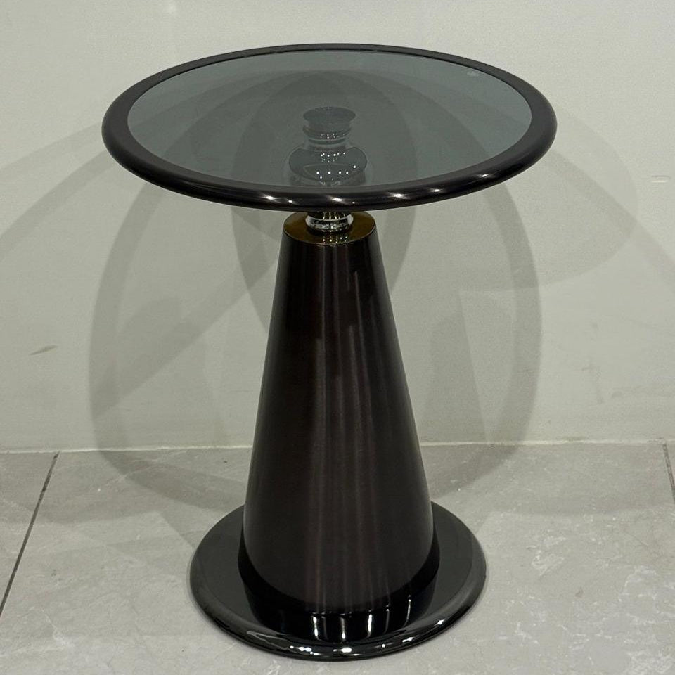 Black side table with glass top on a light gray floor.