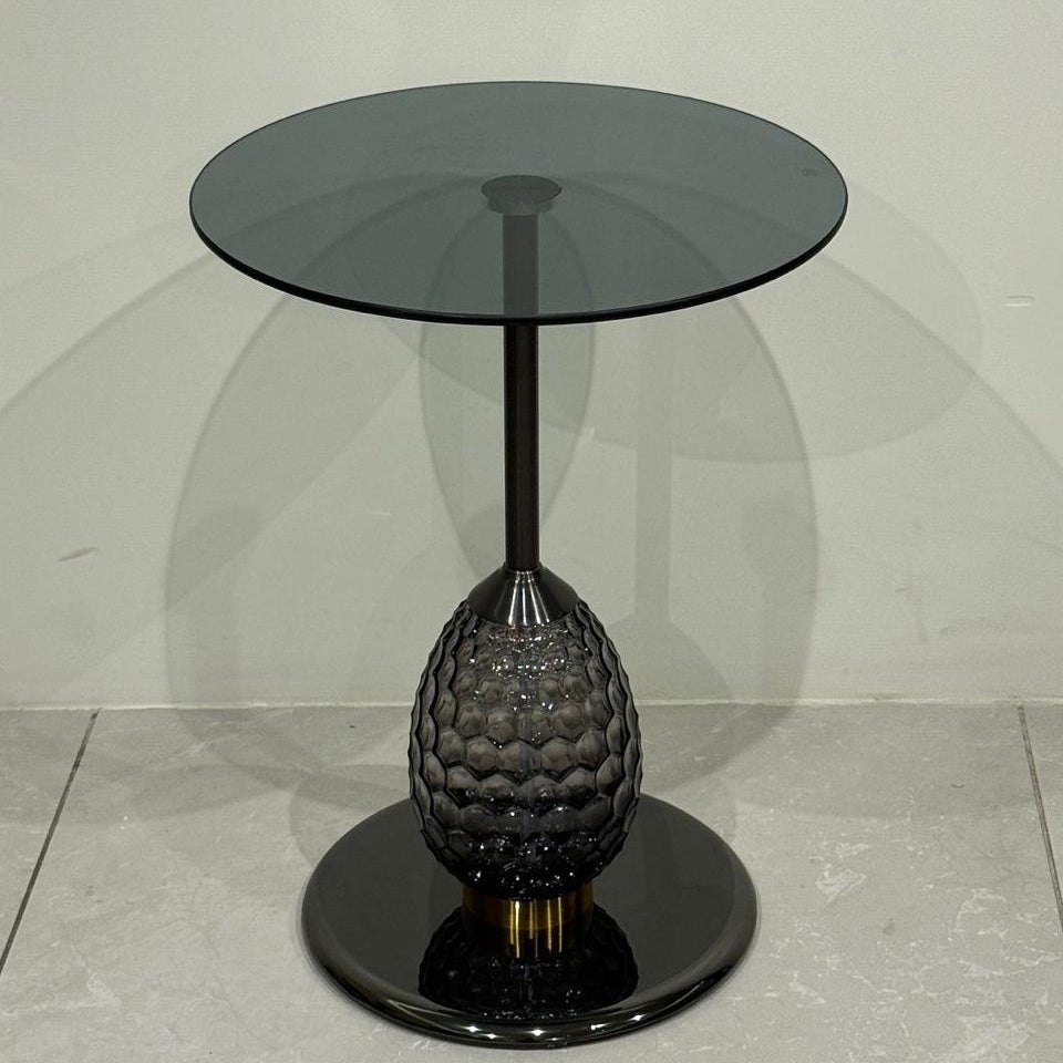 Black side table with glass top on a light gray background
