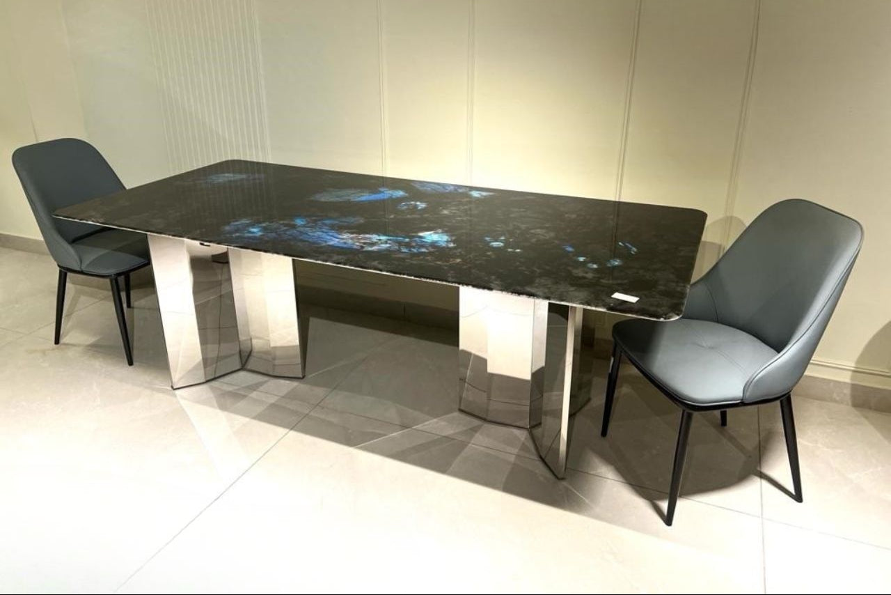 Dining table with marble-like surface and modern chairs in a room setting
