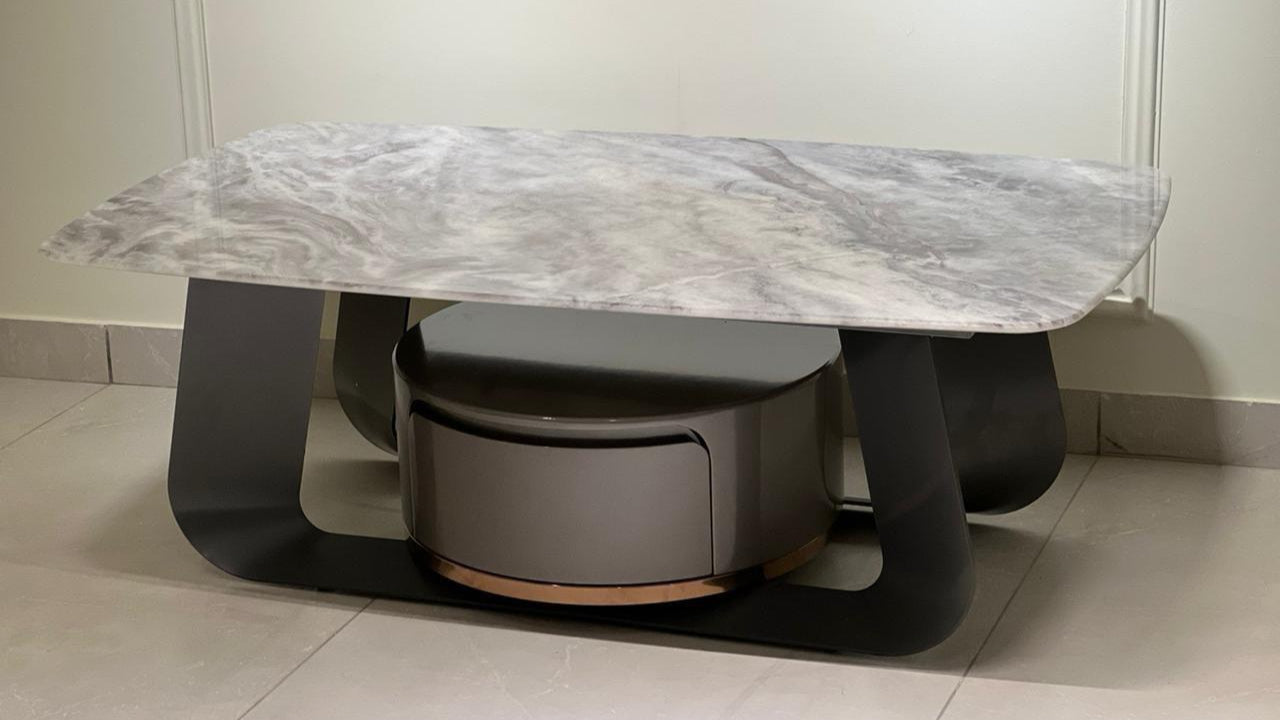Modern marble coffee table with bold black supports and golden accent base — TAS Living
