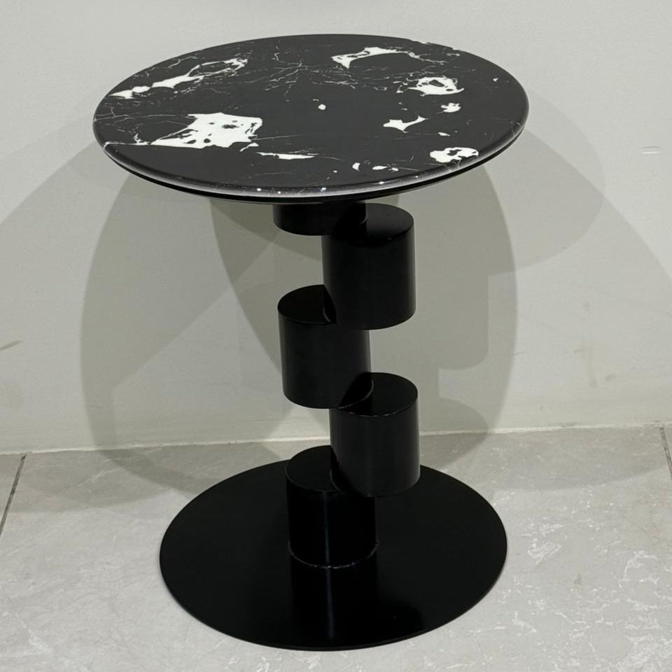 Black side table with abstract design on the top against a light gray background