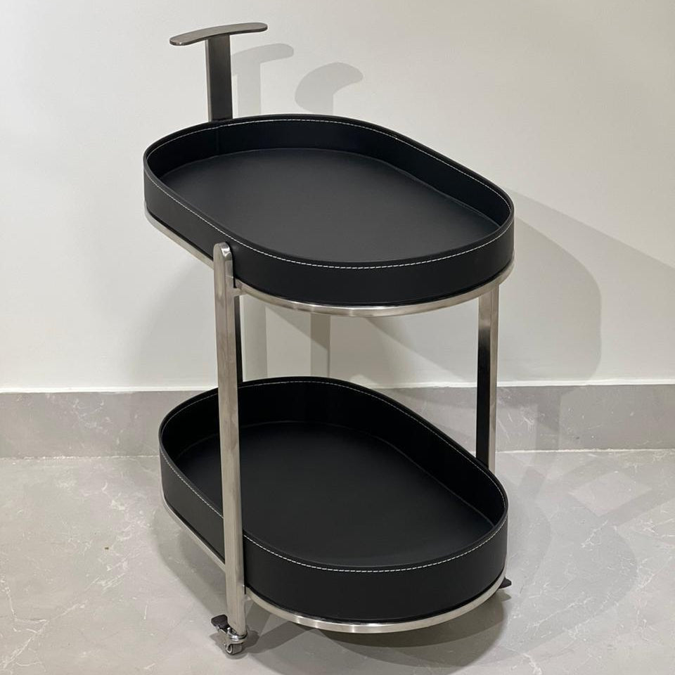 Black serving trolley with metal frame on a light gray floor.
