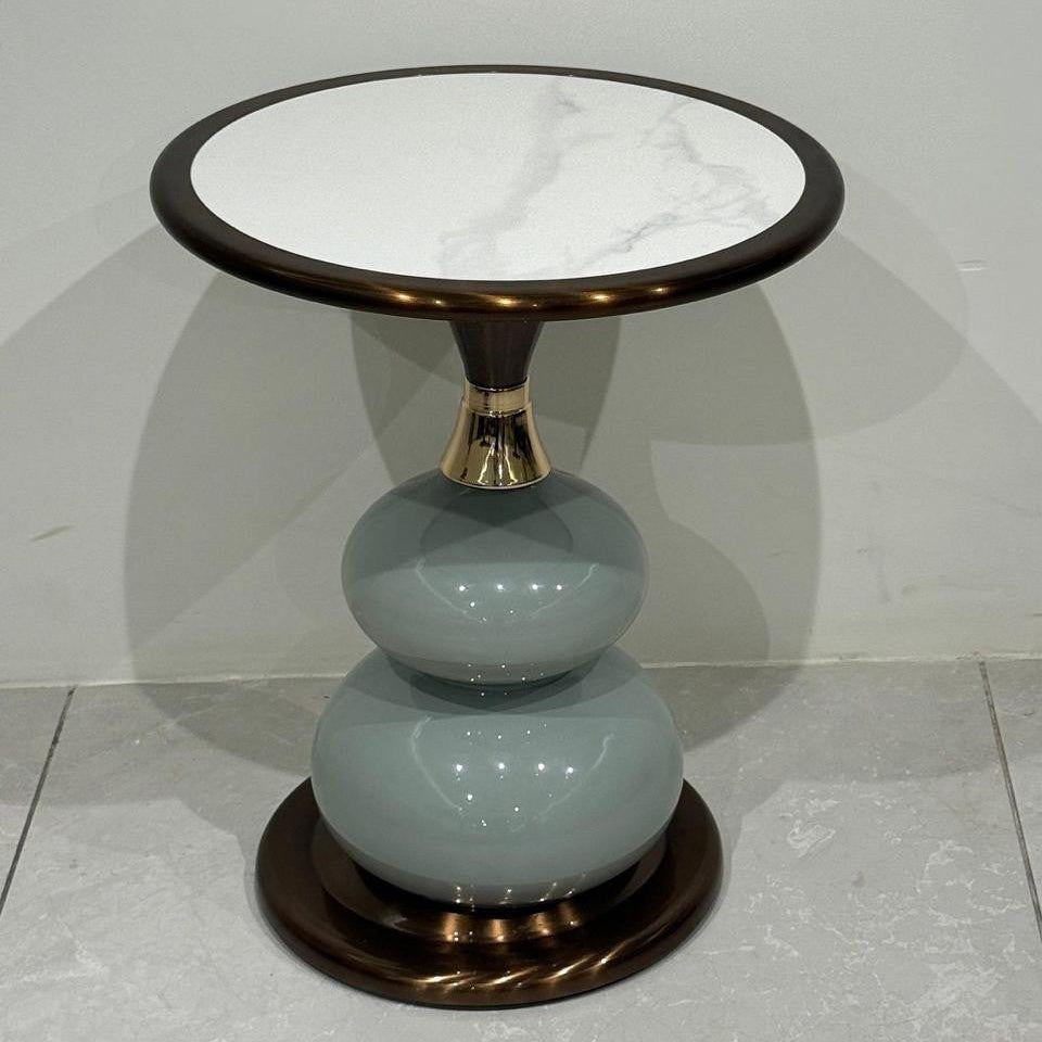 Side table with marble top and ceramic base on a gray background