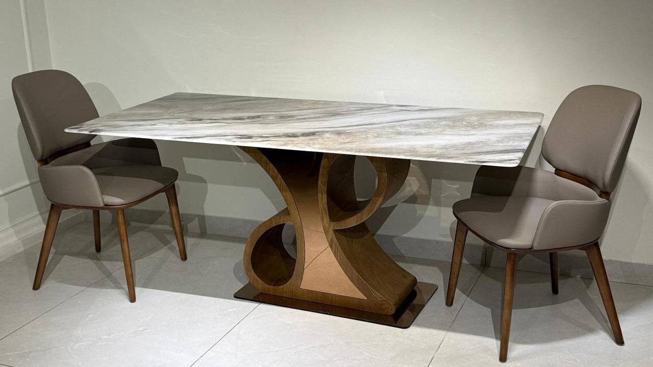 Dining table with marble top and wooden legs, accompanied by two chairs on a light-colored floor.