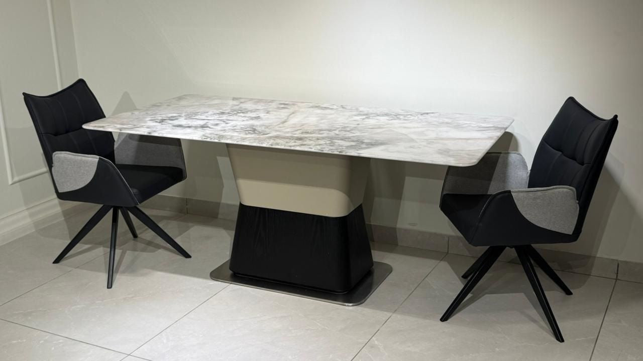 Dining table set with four chairs on a tiled floor against a white wall.