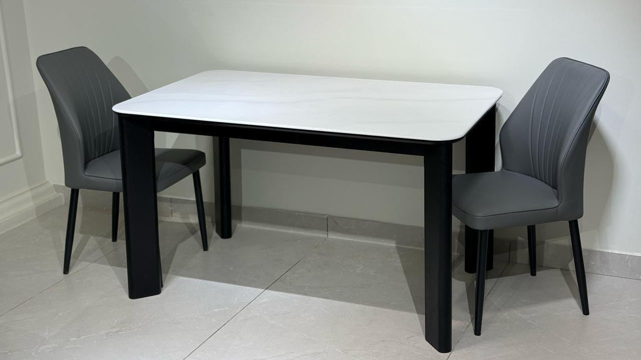 Dining set with a white marble-top table and gray chairs on a tiled floor.