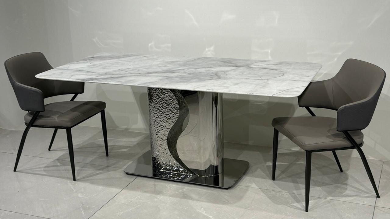 Dining table set with marble top and modern chairs on a tiled floor.