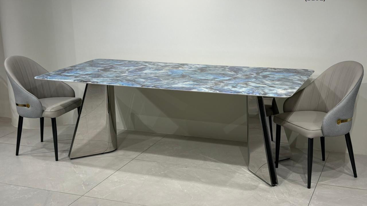 Dining table set with chairs on a tiled floor against a white wall