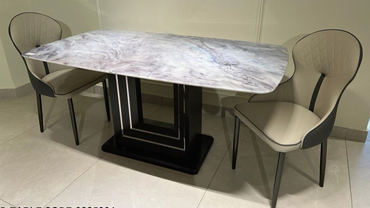 Dining table set with marble top and chairs on a tiled floor.