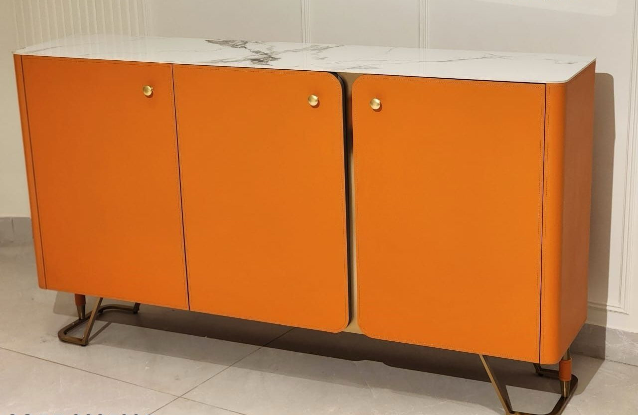 Orange cabinet with white top on a tiled floor against a white wall