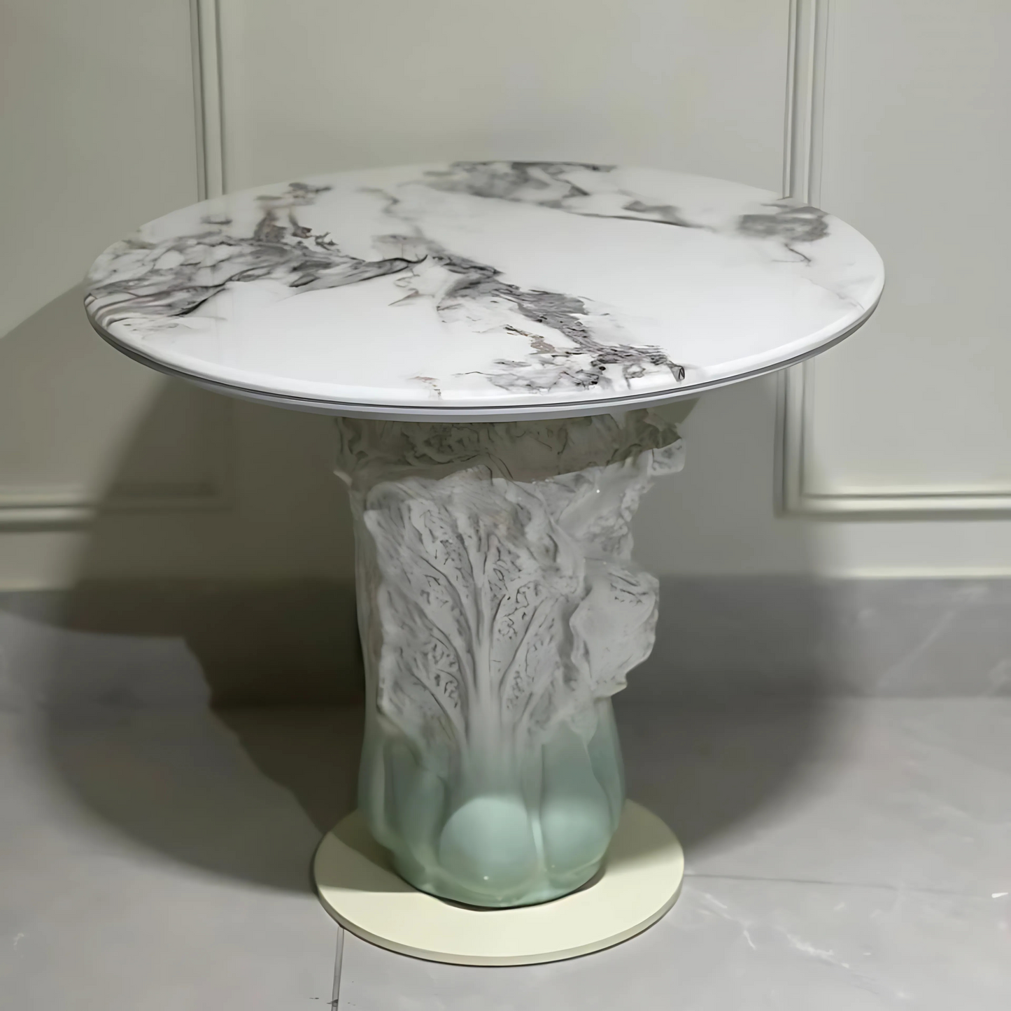Marble-topped luxury side table with jade-toned sculptural ceramic base inspired by botanical roots.

