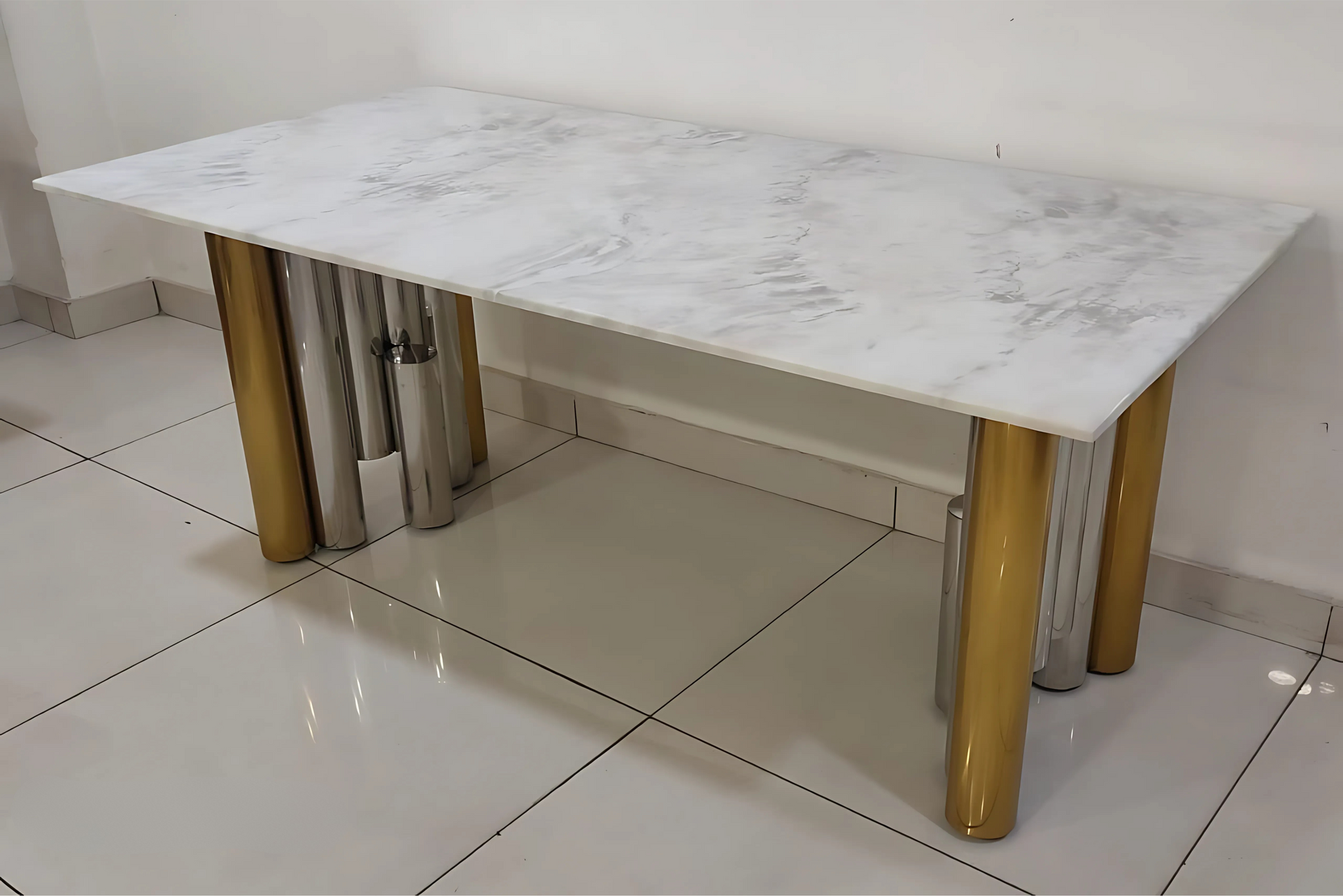 White marble dining table with cylindrical gold and silver chrome legs in a luxury modern design