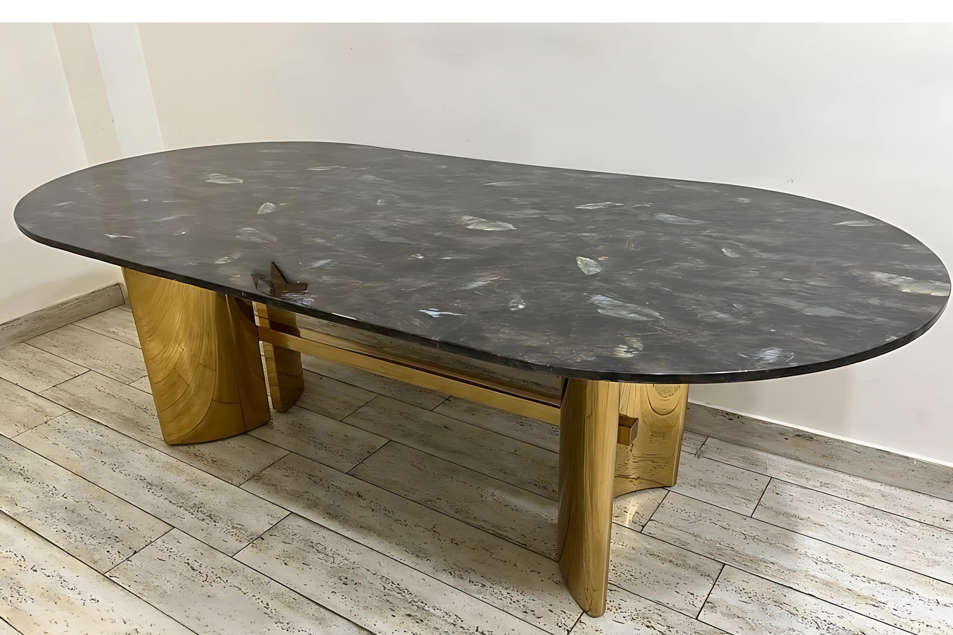 Oval black marble dining table with satin gold sculptural legs in luxury modern style