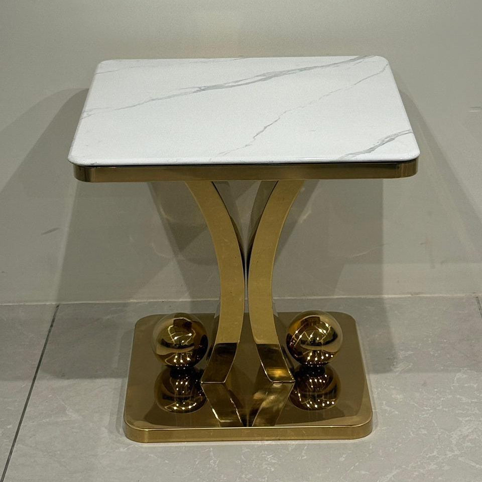 Side table with marble top and gold base on a gray background
