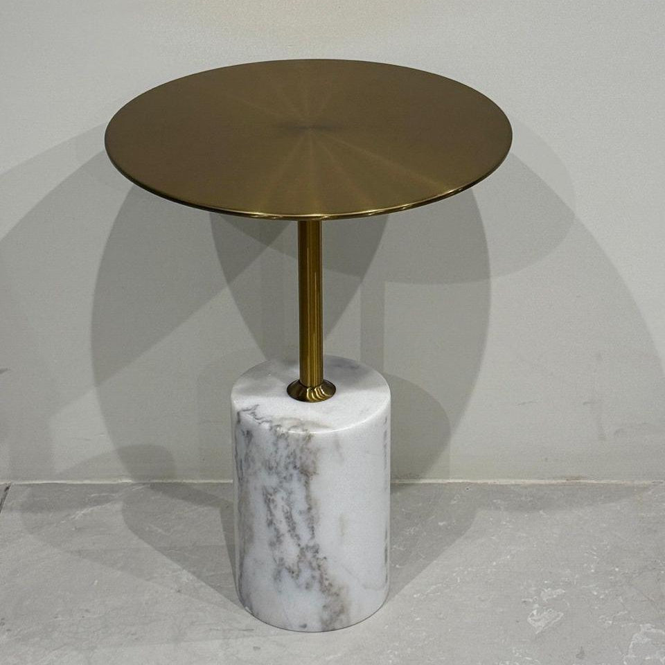Side table with brass top and marble base on a gray background