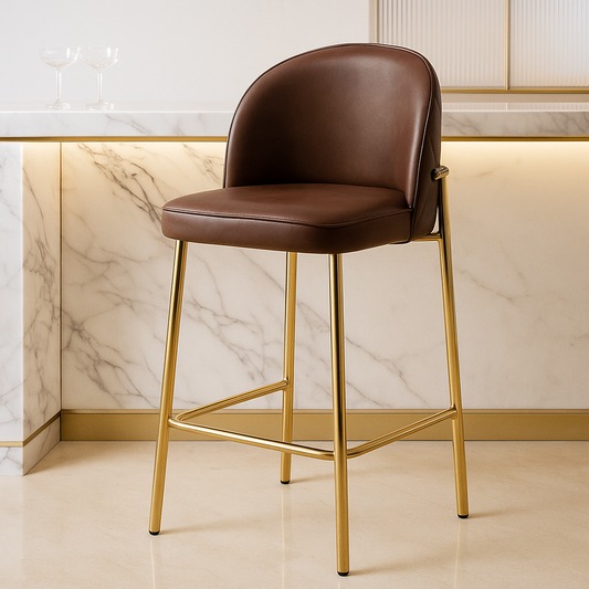Brown bar stool with gold legs against a marble wall.