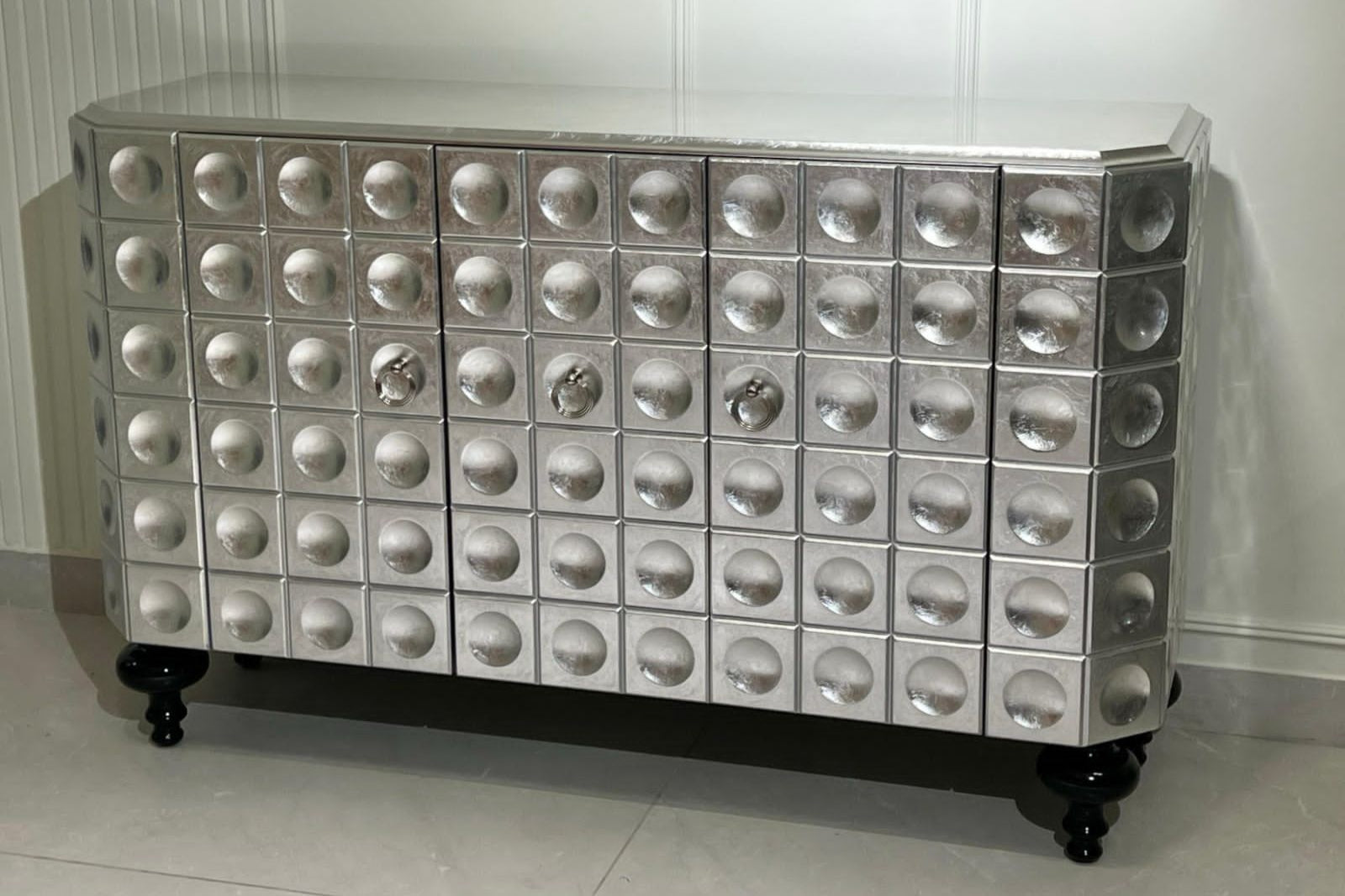 Silver metallic chester table with circular and square designs on a white background