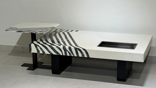 Rectangular white marble center coffee table with black zebra inlay and integrated tray on black pedestal base.

