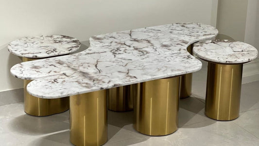 Organic marble cluster center table with golden cylindrical legs and matching side units

