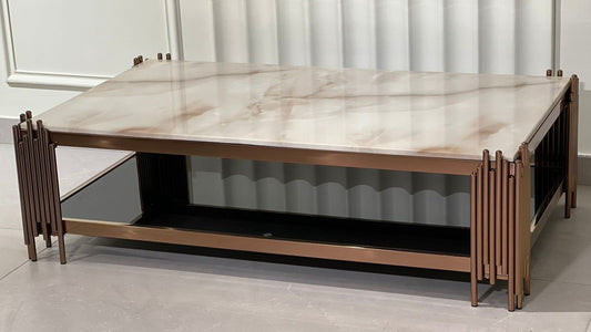 Rectangular rose gold coffee table with marble top and vertical accent legs in luxury setting