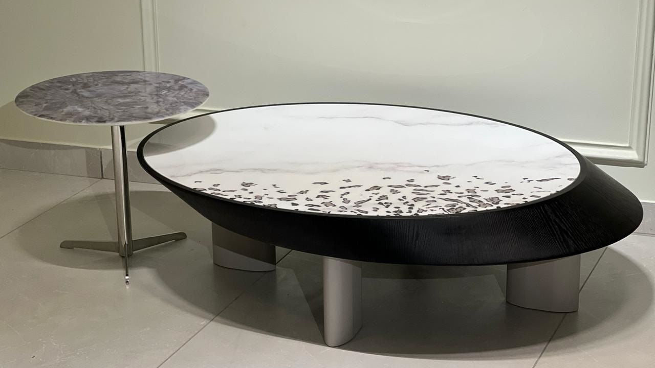 Sculptural marble center table with black wood rim and grey round marble side table on steel base