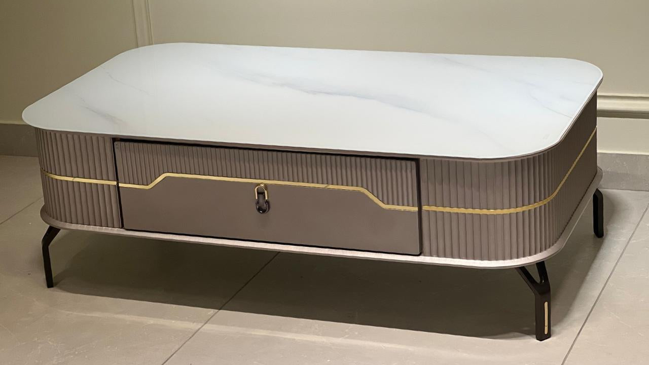 Rectangular marble-effect coffee table with fluted taupe body, gold inlay, and black tapered legs