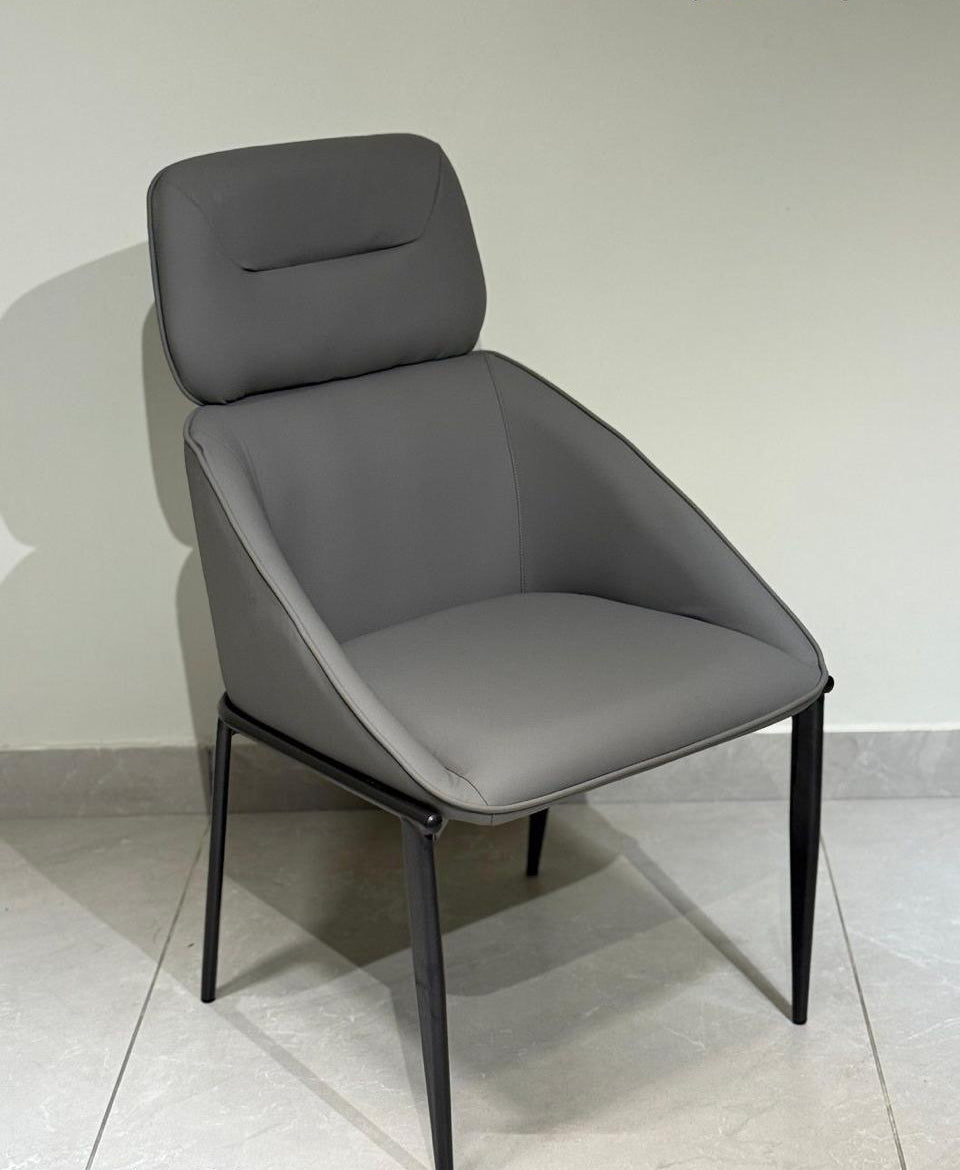 Dark grey dining chair on a light gray floor with a white background