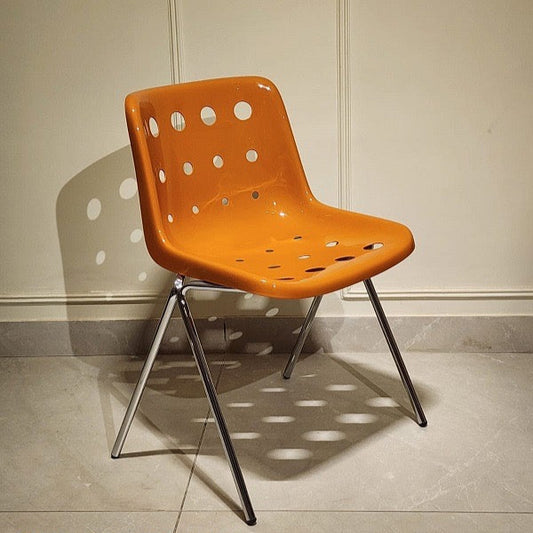 Modern orange designer chair with perforated backrest and chrome legs