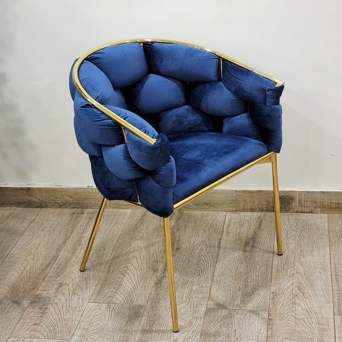Blue velvet accent chair with bubble cushion design and gold frame