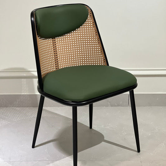 Green upholstered dining chair with cane backrest and black legs